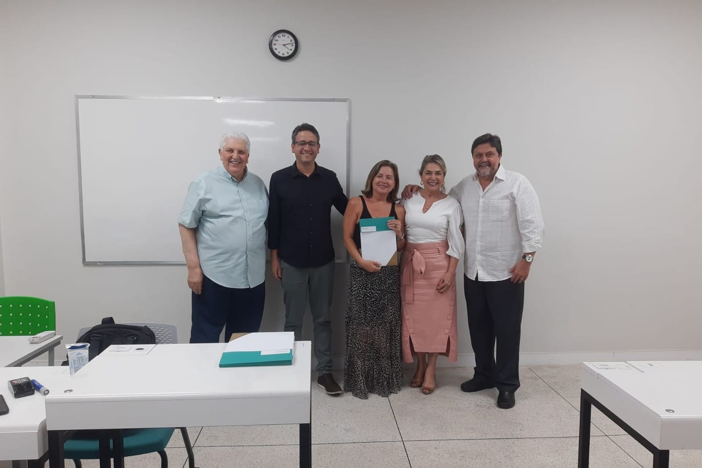 Dra. Gláucia Paixão, com o certificado nas mãos, ao lado do coordenador e dos professores do curso para especialistas na Feluma.